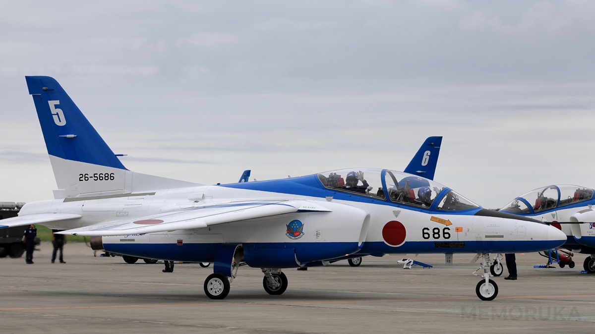 コックピットから観客に手を降って応えるブルーインパルスのパイロット