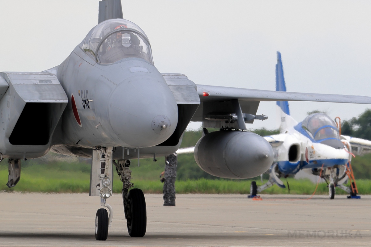 訓練飛行開始に向けて、エプロンから滑走路に向け移動を開始したF-15の写真。背後にはT-4ブルーインパルスも